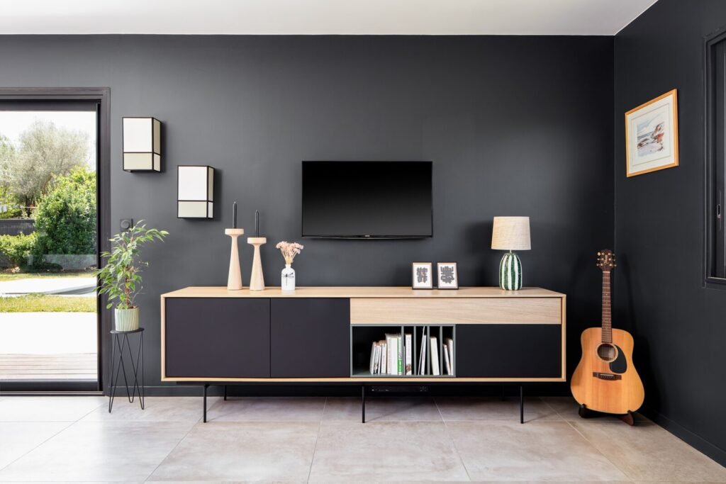 Séjour d'une maison contemporaine, buffet en bois et noir sur mur anthracite