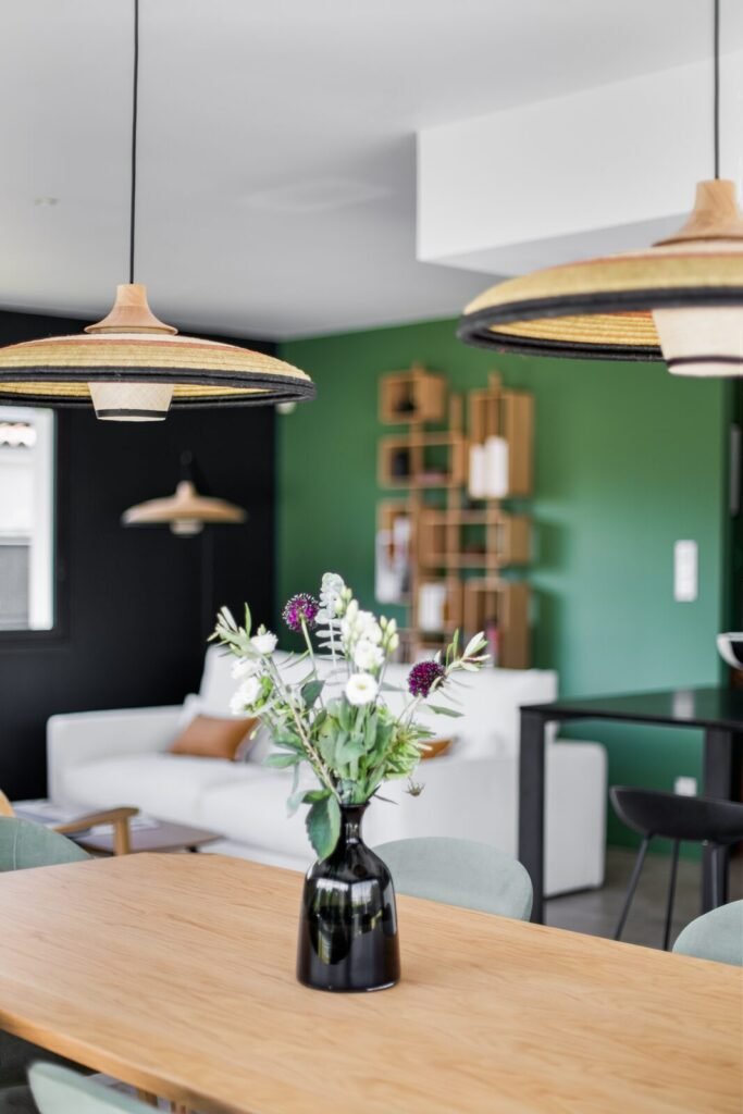 Vue depuis la table à manger vers le salon et son mur d'accent vert